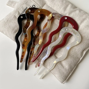 Detail of 7 acetate U-shaped hair pins with crystals on a beige linen pouch
