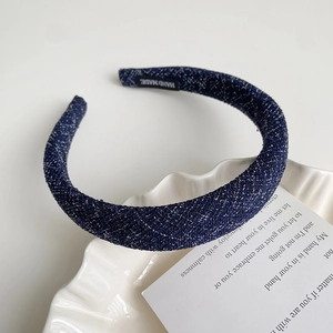 Détail du serre-tête en tweed bleu foncé avec paillettes argentées et étiquette faite main
