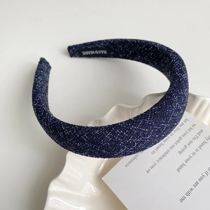Détail du serre-tête tressé bleu marine avec fil brillant et étiquette faite à la main