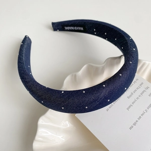 Détail du serre-tête rembourré bleu foncé orné de strass argentés étincelants
