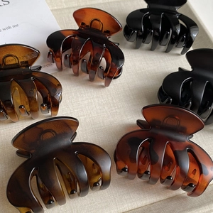 Matte amber and black medium hair claws in a stylish minimalist shark clip design