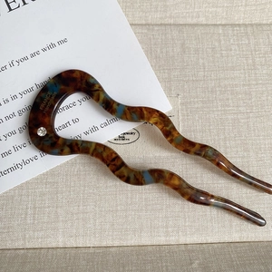Detail of tortoise shell acetate U-shaped hair pin with wave design and crystal