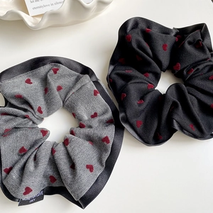 Close-up of heart pattern scrunchies with red velvet hearts and branded label