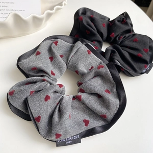Detail of gray and black scrunchies with red hearts and Blind For Love woven labels
