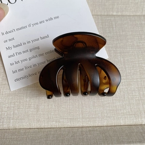 Detail view of a medium dark brown amber hair claw clip with a matte resin finish