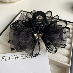 Detail of a large black mesh bow hair claw with a sparkling rhinestone butterfly accent