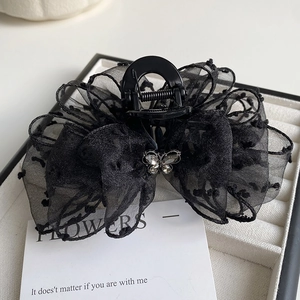 Detail of black mesh lace hair claw with layered bow and silver butterfly rhinestone