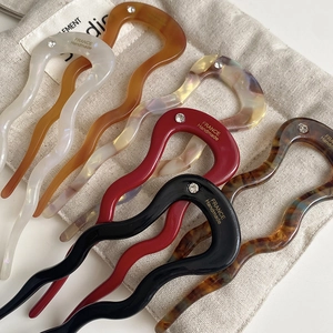 Detail of multi-color acetate U-shaped wave hair pins with crystal inlay on linen pouch