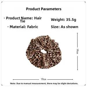 Detail view of large leopard print velvet scrunchie showing 19cm size and soft texture