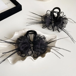 Elegant black mesh bow hair claw clips with feather accents and sparkling rhinestones