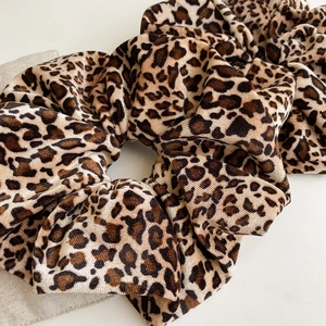 Detail of velvet leopard print scrunchie showing soft texture and high elastic pleats