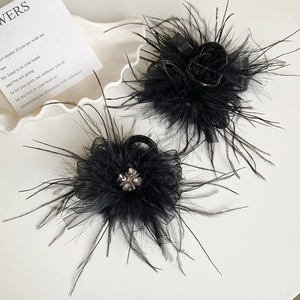 Macro detail of elegant black feather hair clips with rhinestone heart centers