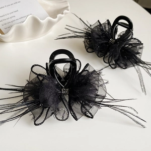 Detail of elegant black hair clips with organza bows, feathers and crystals