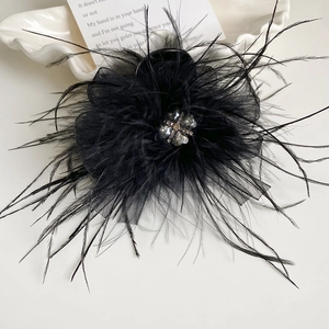 Detail of black feather hair claw clip with crystal flower and mesh textures