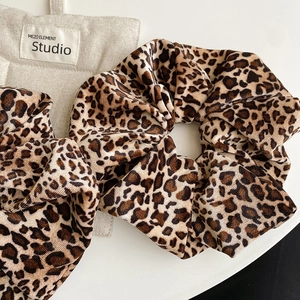 Detailed view of the leopard print velvet scrunchie showing soft texture and pleated design