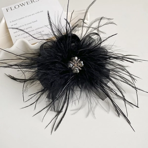 Detail of elegant black feather hair clip with clover rhinestone and mesh bow decoration