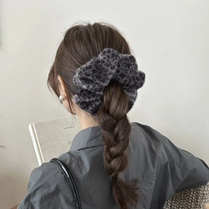 Close-up of gray leopard print plush scrunchie with soft fluffy texture for autumn winter