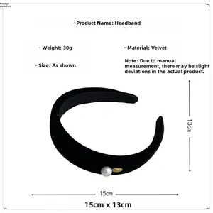 Detail of black velvet headband with white pearl and golden metal emblem