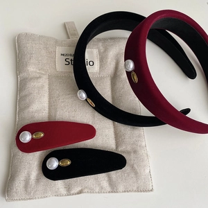 Close-up of velvet pearl headbands and hair clips in burgundy and black colors