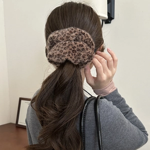 Detail view of leopard print plush hair scrunchie on a ponytail with a soft texture
