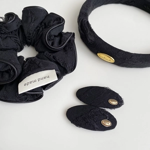 Macro shot of vintage black distressed fabric hair accessories with gold handmade plaques