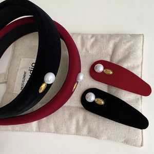 Close-up of velvet pearl headbands and teardrop clips in black and wine red colors
