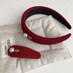 Detail of burgundy velvet headband and hair clip with pearl and golden plate