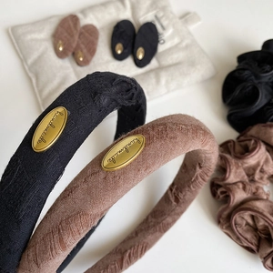 Close-up of vintage fabric headband with golden metal handmade tag and refined texture