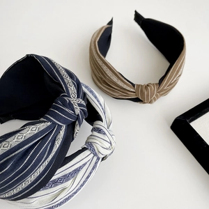 Close-up of wide knotted headbands featuring vintage stripes and geometric embroidery