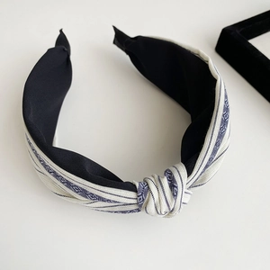 Detailed view of the knotted fabric texture on the striped sea salt blue retro headband