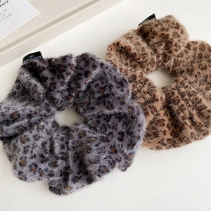 Detail of soft leopard print faux fur scrunchies with stylish decorative text labels