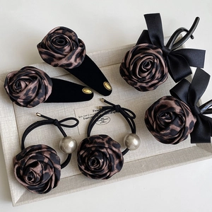 Detailed macro view of vintage leopard print hair accessories set with pearls and velvet