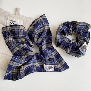 Navy and beige plaid scrunchie set with matching ribbon hair tie on linen fabric