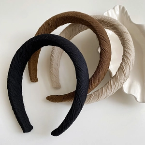 Three padded sponge headbands in black, brown, and apricot with pleated fabric texture