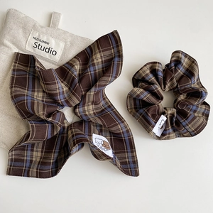 Detail of plaid scrunchie and matching headband set with cute bear woven labels