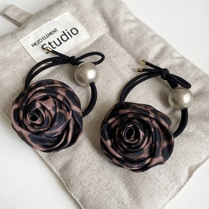Close-up of leopard print silk rose hair ties with champagne gold pearl and black elastic