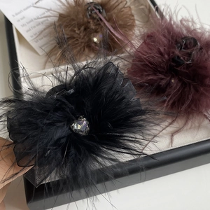 Detailed view of elegant feather hair claws with crystal heart and mesh base