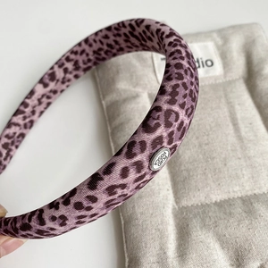 Stylish purple leopard print headband with a premium silver metal logo plaque for women