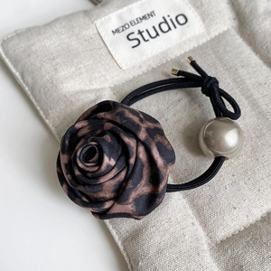 Detail of leopard print fabric rose hair tie with a glossy grey faux pearl and dual cord