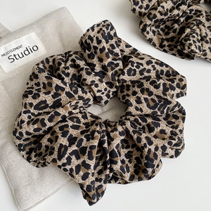 Detail showing high-quality leopard print scrunchies with elegant fabric pleats