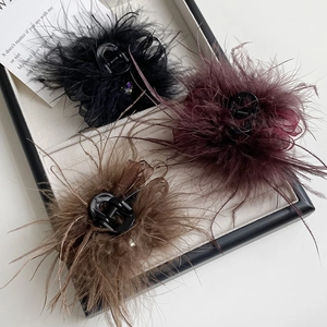 Detail view of feather claw clips with rhinestones in black burgundy and coffee colors