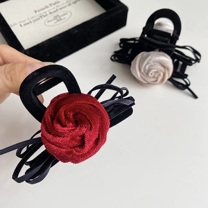 Detail view of elegant velvet rose hair claw clips in burgundy and creamy white colors