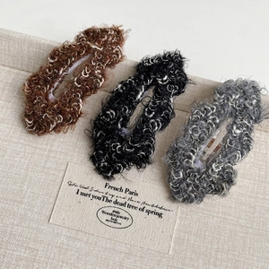 Three plush autumn hair clips in brown black and grey with warm curly lamb wool texture