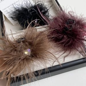 Close-up of feather hair claws in black, burgundy, and brown with crystal hearts