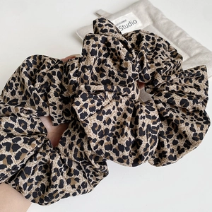 Close-up of brown leopard print scrunchies showing pleated chiffon texture and soft fabric