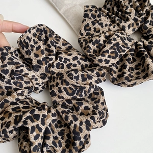 Close-up of leopard print oversized scrunchies with soft pleated fabric texture