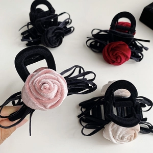Close-up of velvet rose hair claw clips with multi-layered silk ribbons in four colors