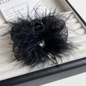 Detailed macro view of black feather hair claw clip with a sparkling heart diamond centerpiece