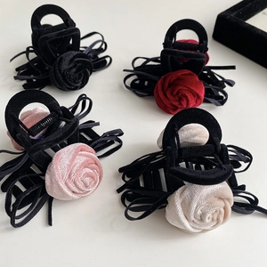Detailed macro view of four elegant velvet rose hair claws with ribbons and satin flowers