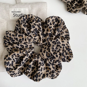 Detail shot of leopard print scrunchie fabric texture and rich pleated elastic design